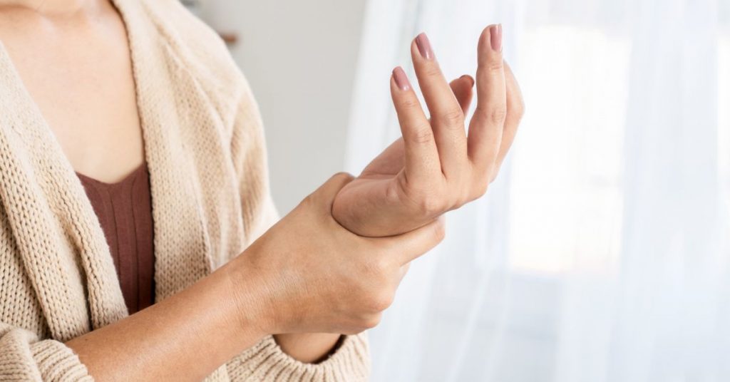 woman holding her painful wrist